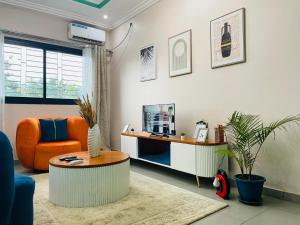 a living room with an orange chair and a desk at Matera YameHome in Yaoundé