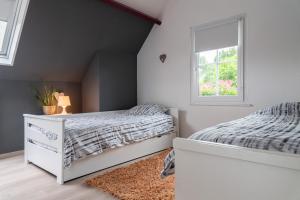 een slaapkamer met een wit bed en een raam bij Gite Au Chant d'Eole in Ebly