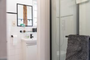 een witte badkamer met een wastafel en een douche bij Gite Au Chant d'Eole in Ebly