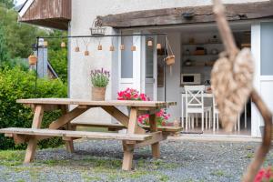 een picknicktafel en bank voor een huis bij Gite Au Chant d'Eole in Ebly