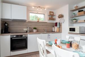 a kitchen with a table with chairs and a microwave at Gite Au Chant d'Eole in Ebly