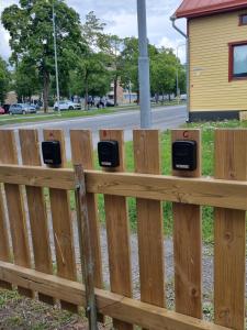 Una valla de madera con tres teléfonos públicos. en Kompakti yksiö numero 12 pienkerrostalossa, en Pori