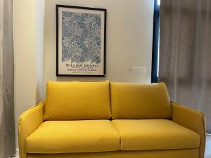 un divano giallo in soggiorno con una foto di Osito Hub - Campoamor a Valencia Altre 24 foto