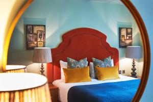 a bedroom with a bed with blue walls and a mirror at Hotel Du Vin Edinburgh in Edinburgh