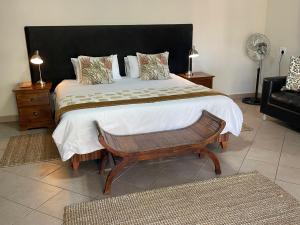 Un dormitorio con una cama grande y una silla. en Zomoya Game Farm, en Vaalwater