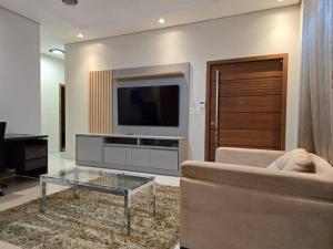 a living room with a couch and a tv at Confortável como a sua casa! in Ariquemes