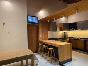 a kitchen with a bar and a tv on the wall at Confortável como a sua casa! in Ariquemes