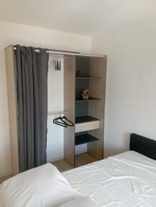 une chambre avec un lit et une étagère dans l'établissement Lueurs des marées, à Merlimont