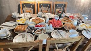 a wooden table with plates of food on it at Guesthouse Chela in Mestia