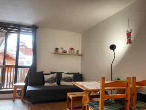 a living room with a couch and a table at Cosy central Studio with a view, balcony 20m2 4ppl in Vénosc
