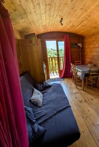 a large bed in a room with a table at Roulotte du Mas Rondole in Saillagouse +18 photos