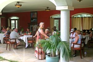 a woman standing in a restaurant with people sitting at tables at Hawaii Island Retreat at Ahu Pohaku Ho`omaluhia in Kapaau