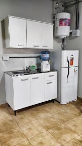 a kitchen with white cabinets and a refrigerator at Saenz Peña x 4 in Venado Tuerto