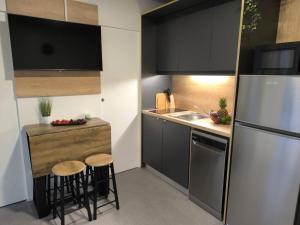 トゥラニにあるLuxury Ondina- Beachfront Retreatのキッチン(冷蔵庫付)、カウンター(スツール付)