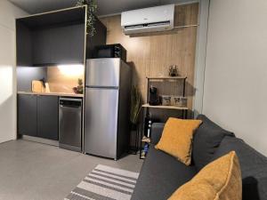 トゥラニにあるLuxury Ondina- Beachfront Retreatのキッチン(冷蔵庫、ソファ付)