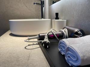 un ripiano del bagno con asciugacapelli e asciugamani di Osito Hub - Campoamor a Valencia