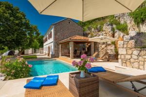 a villa with a swimming pool and a house at Villa Mare Monti in Drivenik