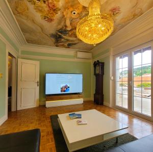 a living room with a flat screen tv and a table at Apartment Bakarosa in Pučišća