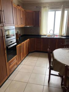 a kitchen with wooden cabinets and a stove top oven at Casa da Piedade in Piedade