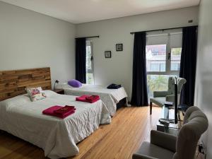 a hotel room with two beds and a chair at Casa Premium Habitaciones in Buenos Aires +59 photos