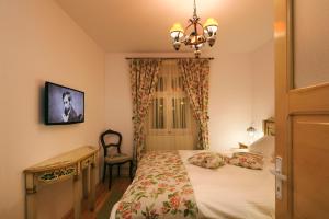 a bedroom with a bed and a desk and a chandelier at Apartment Wine House in Sibiu