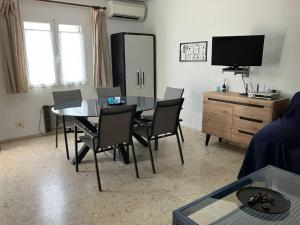 a living room with a table and chairs and a tv at Denia El Palmar 183 in Denia