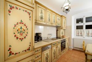 a kitchen with wooden cabinets with a floral pattern on the wall at Apartment Wine House in Sibiu