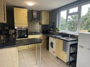 a kitchen with wooden cabinets and a washer and dryer at Signet Luxury 3-bedrooms, 2bathrooms House with WiFi & Netflix in Rochester