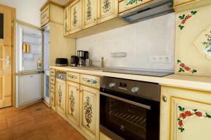 a kitchen with wooden cabinets and a black oven at Apartment Wine House in Sibiu +3 photos