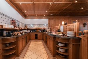 a large kitchen with wooden cabinets and counters at Lüch Da Pćëi in San Cassiano