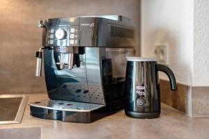 una cafetera sentada en un mostrador junto a una taza en Km Style Apartments 6, en Freiburg im Breisgau