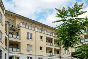 un edificio de apartamentos con balcones y una palmera en Km Style Apartment Nr 1, en Freiburg im Breisgau