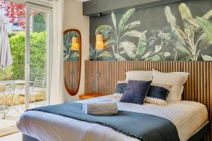 a bedroom with a large bed with blue pillows at Studio chic piscine, jardin et parking, Lyon 3 in Lyon