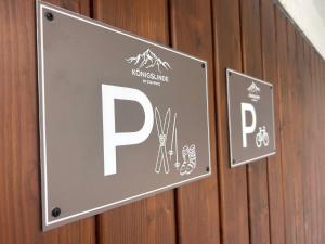 a sign on the wall of a building with a p on it at Hotel garni Königslinde - Wandern, Radeln, Skifahren & Genießen in Bayrischzell