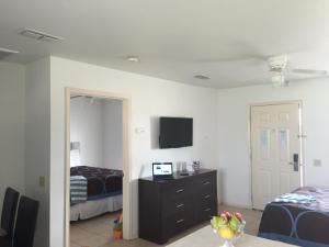 a bedroom with two beds and a television on the wall at Port Isla Inn in Port Isabel