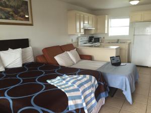 a small room with a bed and a kitchen at Port Isla Inn in Port Isabel