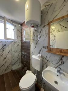 un baño con inodoro y lavabo en Lotos Apartments, en Struga 29 fotos más