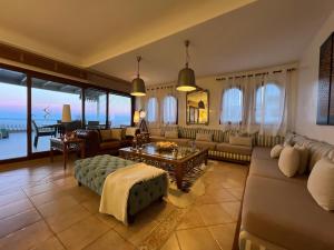 uma sala de estar com um sofá e uma mesa em Luxury Apartment Beach View by Marina Beach em M'diq