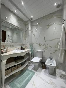 um banheiro com uma pia, um vaso sanitário e um espelho em Luxury Apartment Beach View by Marina Beach em M'diq