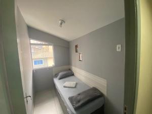 a small room with a bed and a window at Suíte para Homens Próximo ao Aeroporto e Metro in Sao Paulo