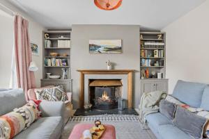 a living room with a couch and a fireplace at The Old Shop House in Galmpton-on-the-Dart