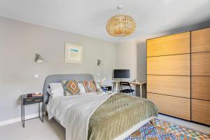 a bedroom with a bed with a large wooden dresser at The Old Shop House in Galmpton-on-the-Dart