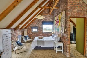 Un dormitorio con una cama en una pared de ladrillos. en Mountain View, en Bettyʼs Bay