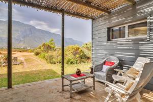 Un patio con dos sillas y una mesa y vista a las montañas. en Mountain View, en Bettyʼs Bay