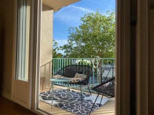 an open door to a balcony with a chair on a deck at Hypercentral flat for 6 in Lorient in Lorient