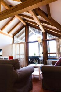 a living room with couches and a large window at Gästehaus Rössler in Brannenburg