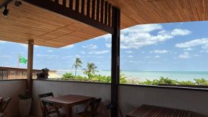 a balcony with a table and chairs and the ocean at Pousada Amazing Jeri in Jericoacoara