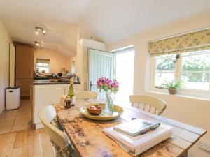 a kitchen and dining room with a wooden table at Shoemakers Cottage, Friston in Friston