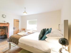 a bedroom with a large white bed with pillows at Shoemakers Cottage, Friston in Friston