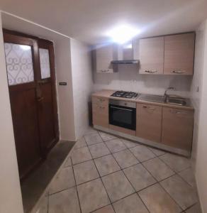 a kitchen with a stove and a sink and a door at Il rifugio dell'escursionista in Casperia